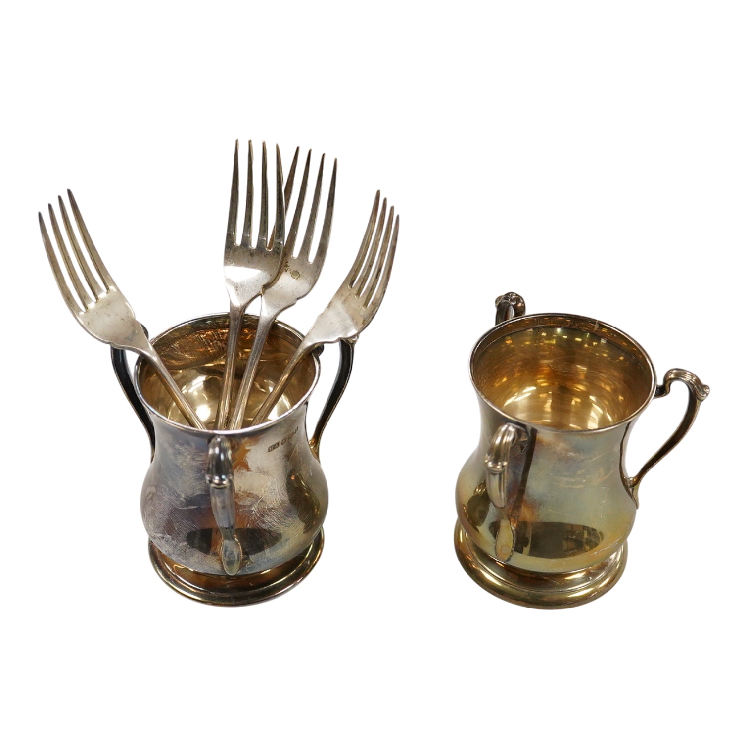 Two George V silver loving cups, one by Atkin Brothers, Sheffield, 1926, height 89mm and a set of four silver Hanoverian pattern dessert forks, Birmingham, 1930, 16.4oz.